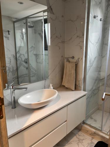 a bathroom with a sink and a shower at Moderno y luminoso departamento in Tandil