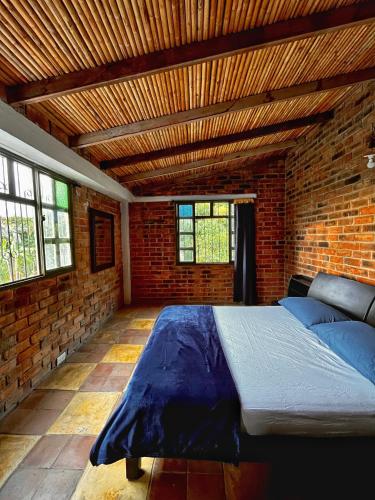 a bedroom with a large bed in a brick wall at El Cerrito Ventanas Parapente - Bed and Breakfast Premium in Piedechinche