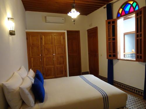 a bedroom with a large bed and a window at Riad Sabah in Fès
