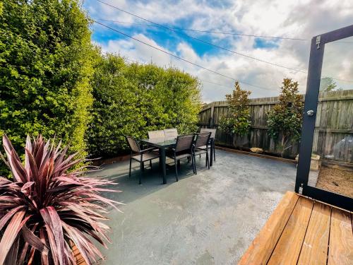a patio with a table and chairs on a deck at Three-Bedroom Stylish & Cosy Retreat with Courtyard, Near Geelong in Norlane
