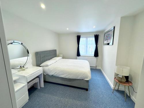 a bedroom with a bed and a sink and a mirror at 3bed 2bath House-Free Parking-Fast WiFi-Garden-Entire Home-2mins from Train Station-Sleeps 6 in London