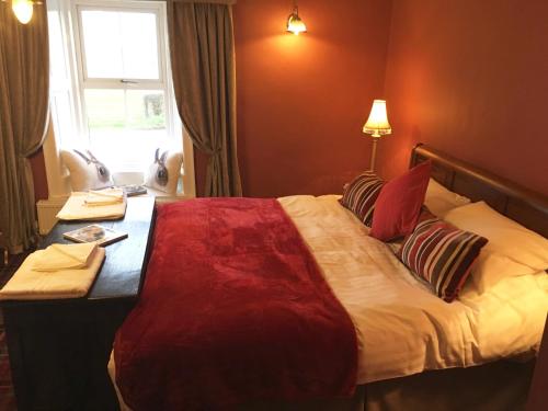 a hotel room with a large bed with a desk at Robin Hood Inn in Wall Houses