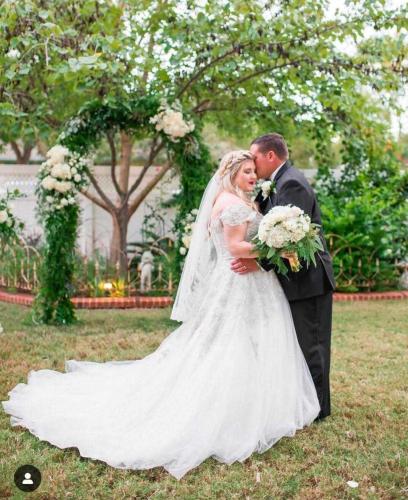 a bride and groom kissing in the grass at The Abbott House & Event Venue in Seguin