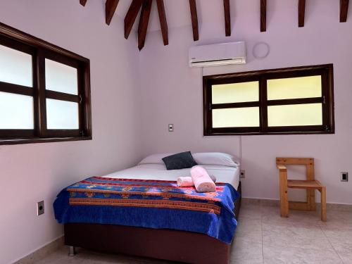 a bedroom with a bed with a pink towel on it at Finca Hotel Villa Tara in Barbosa