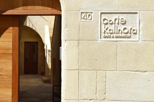 a building with a sign on the side of it at Corte Kalìnora in Martano