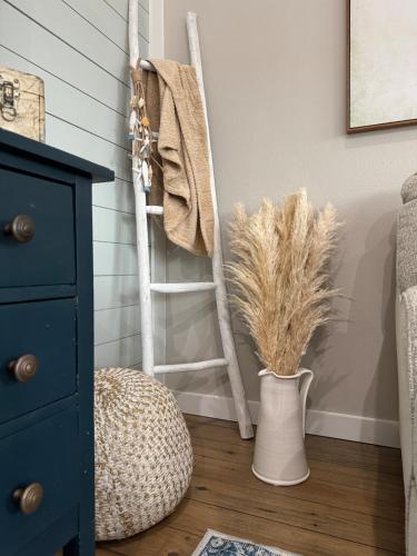 a room with a ladder and a vase with dry grass at Jelly Bay in Bolivar Peninsula