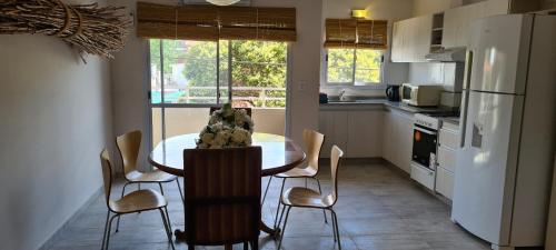 a kitchen with a table with chairs and a refrigerator at Carlos Paz - 3 Dormitorios con cochera - Zona céntrica residencial in Villa Carlos Paz