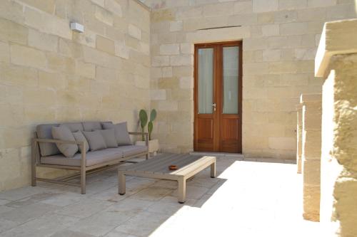a living room with a couch and a coffee table at Corte Kalìnora in Martano