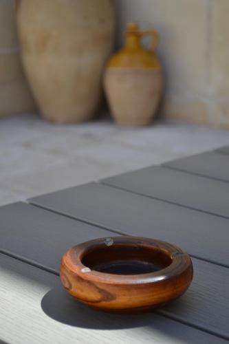 a wooden bowl sitting on top of a table at Corte Kalìnora in Martano