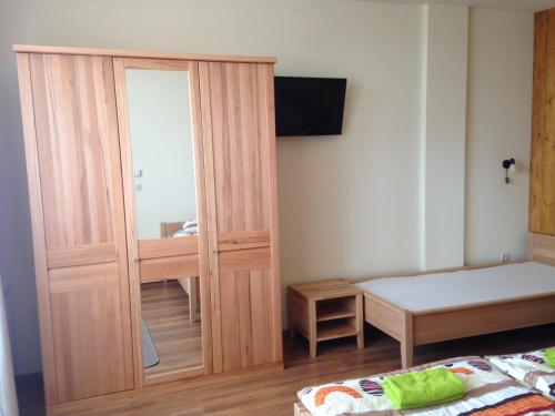 Un dormitorio con un armario de madera con espejo. en Prémium Vendégház, en Zalaszentmihály