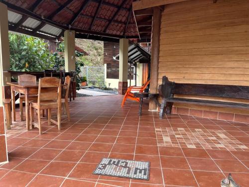 a patio with a bench and a table and chairs at Villa Rancho con Río Privado in Guácimo