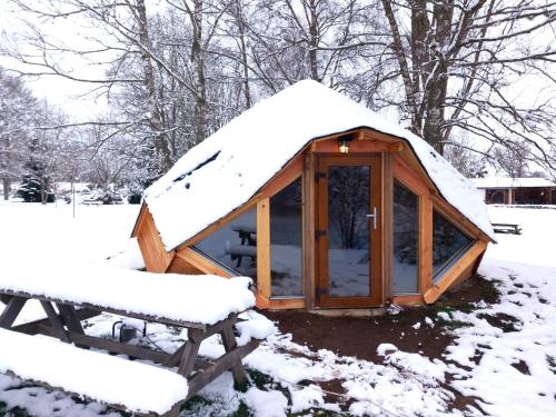 a wooden greenhouse with snow on top of it at Domaine du Balbuzard in Condat-en-Combraille