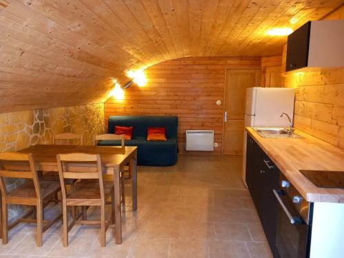 a kitchen and dining room with a table and a couch at Domaine du Balbuzard in Condat-en-Combraille