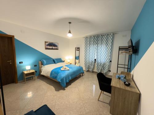 a bedroom with a blue bed and a desk and a chair at Agriturismo Cydonia Home in Ari
