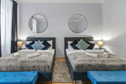 two beds in a room with two mirrors at Fast Wifi I 4 min to U3 Zipperer Straße in Vienna
