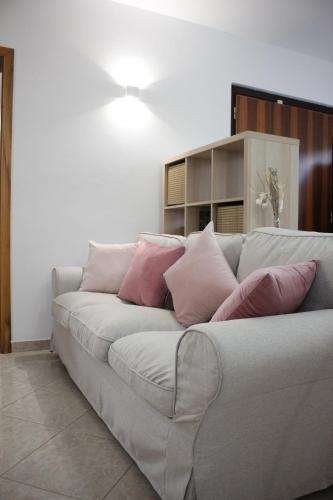 a living room with a couch with pink pillows at Agriturismo Cydonia Home in Ari