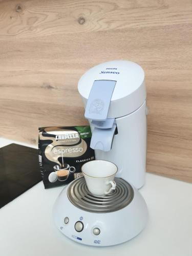 une cafetière et une tasse sur un comptoir dans l'établissement Le Nid champenois, à Reims