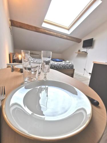 une plaque blanche sur une table avec des lunettes dans l'établissement Le Nid champenois, à Reims