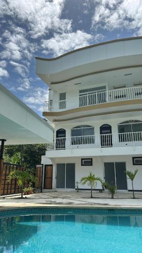 a building with a swimming pool in front of a building at Villa del Mar Hotel Boutique in Cahuita