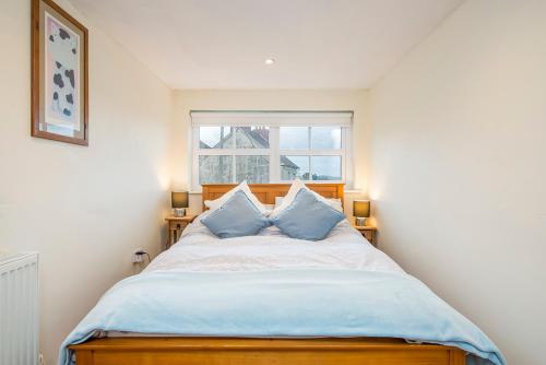 una camera da letto con un letto grande con due cuscini blu di Llys Bonfyl a Cardigan
