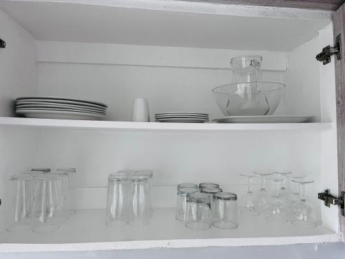 a white shelf with glass jars and plates on it at Ushaka Ocean Escape - Shaka Shores 5E in Durban