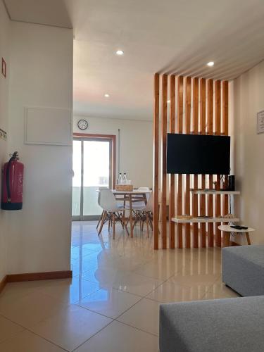 a living room with a television and a table with chairs at Furadise Apartment in Ovar