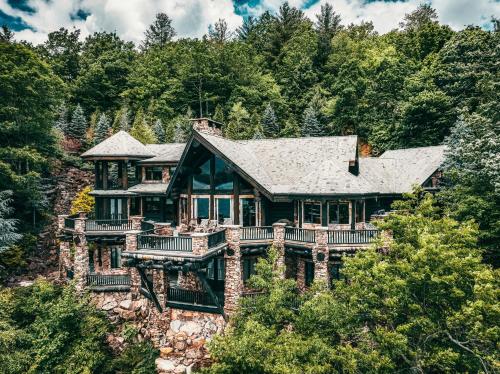 a house on a hill with trees at Lakefront Cabin For Large Groups in Topton