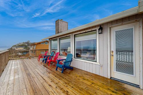 a deck with chairs and a table on it at At The Seaside in Lincoln Beach