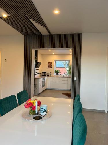 a dining room with a white table and a kitchen at 3 km to Legoland in Billund