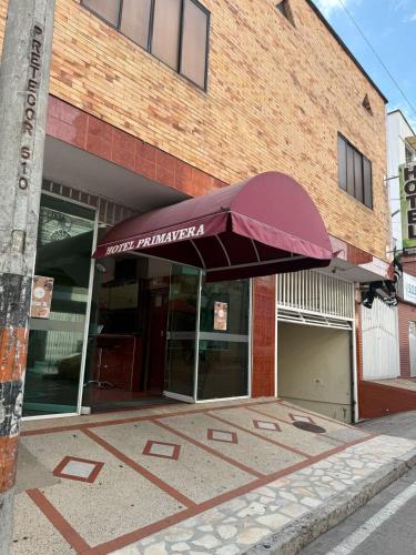 a building with a red umbrella in front of it at Hotel Primavera in Floridablanca