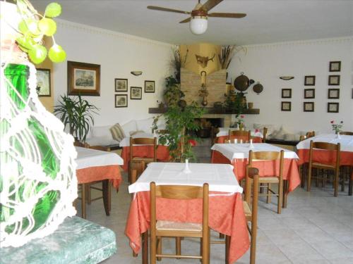 a restaurant with tables and chairs and a ceiling fan at Agriturismo La Selva in Nocera Umbra