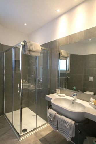 a bathroom with a glass shower and a sink at Hotel Olimpia in Sirmione