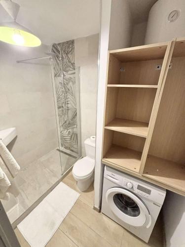 a bathroom with a shower toilet and a washing machine at Le Tiny Studio in Saint-Denis
