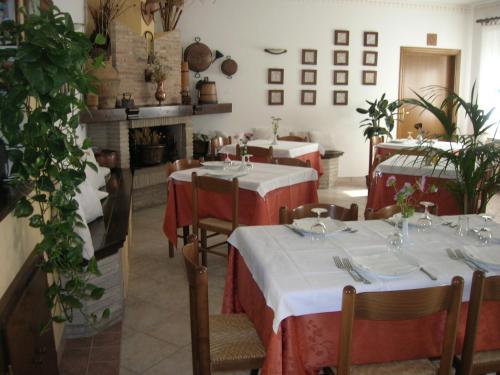 a restaurant with tables with red and white tablecloths at Agriturismo La Selva in Nocera Umbra