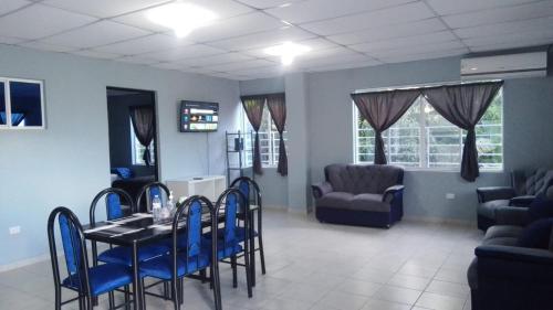 ein Esszimmer mit einem Tisch und blauen Stühlen in der Unterkunft Apartamento Familiar 2 con 3 habitaciones 4 camas y litera in San Salvador