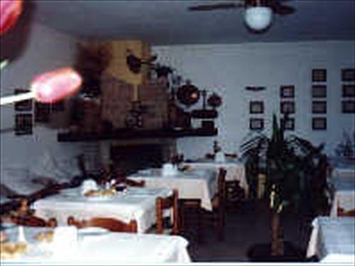 a dining room with white tables and chairs and a room with white tablecloths at Agriturismo La Selva in Nocera Umbra