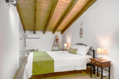 a bedroom with a bed and a wooden ceiling at Viros Holiday House Breathtaking Views & Private Mini Pool Jacuzzi in Corfu in Virós
