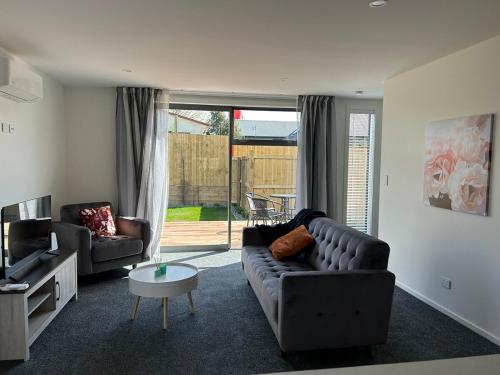a living room with a couch and a table at Apartment 4 on Armagh! in Christchurch