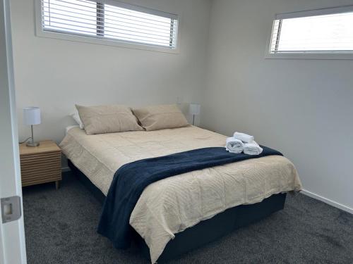 a bedroom with a bed with a blue blanket at Apartment 4 on Armagh! in Christchurch