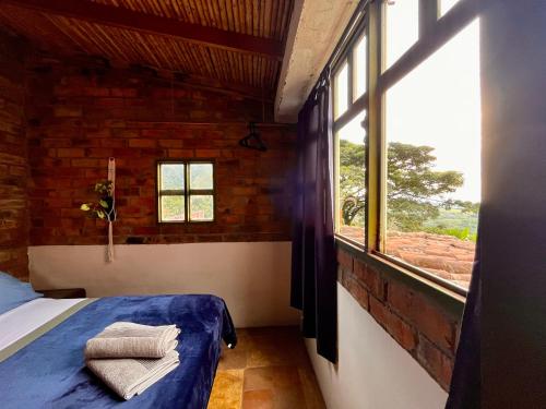 a bedroom with a bed and a large window at El Cerrito Ventanas Parapente - Bed and Breakfast Premium in Piedechinche