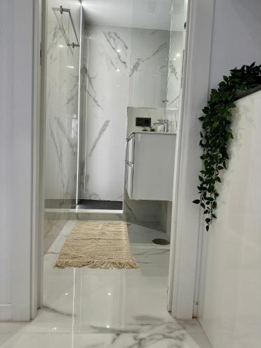a white kitchen with a glass doorway with a rug at Mark Suite B8 in Fuengirola