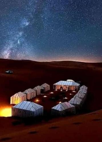 a cluster of domes in a desert at night at Desert camp camel & sandboarding in Merzouga