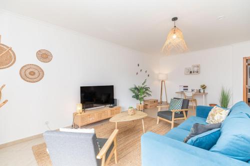 a living room with a blue couch and a tv at Apartment Pepita-tavira Centre, Pool & Garage in Tavira