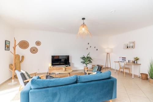 a living room with a blue couch and a table at Apartment Pepita-tavira Centre, Pool & Garage in Tavira
