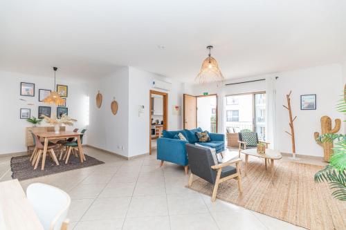 a living room with a blue couch and a table at Apartment Pepita-tavira Centre, Pool & Garage in Tavira