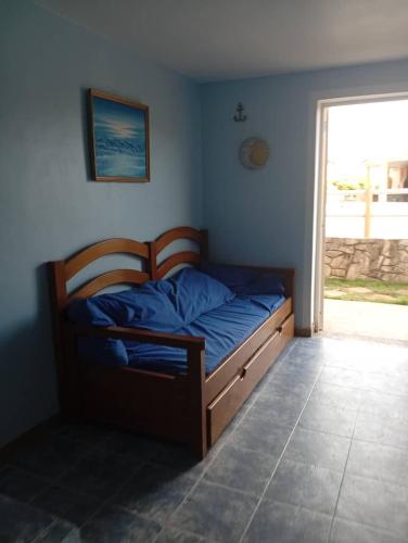 a bedroom with a bed with blue sheets and a window at Townhouse en Chichiriviche AGUILA MARINA 3 in Chichiriviche