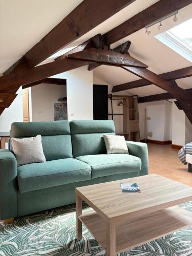 - un salon avec un canapé vert et une table basse dans l'établissement Barrio Cyrano Appartement-Centre Historique, à Bergerac