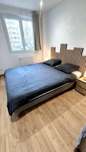 une chambre avec un grand lit et un parquet dans l'établissement Le Necy, entièrement Rénové en 2025, à Annecy