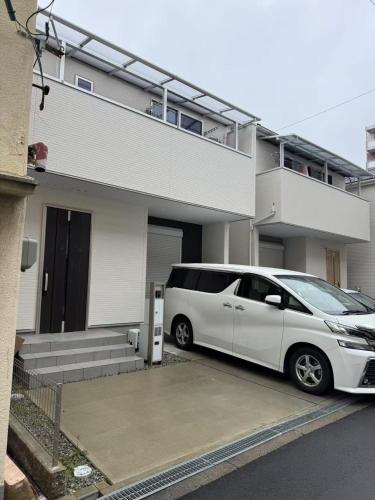 a white van parked in front of a house at 花喜Usj in Osaka