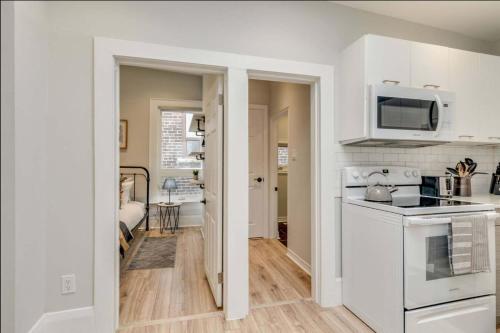 a kitchen with a stove and a microwave at Casa Leslieville - 2BR Suite with LRG Patio in Toronto